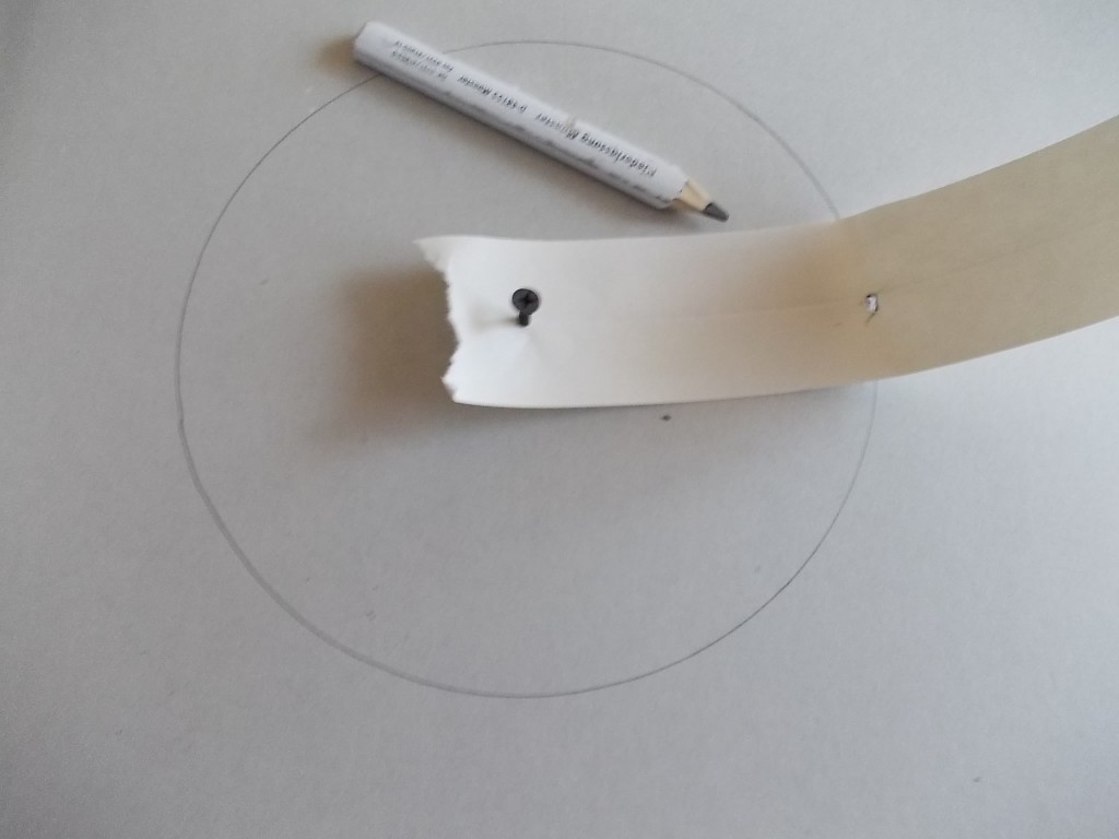 Rysujemy koło przy pomocy wkrętu, ołówka i taśmy papierowej do szpachlowania.